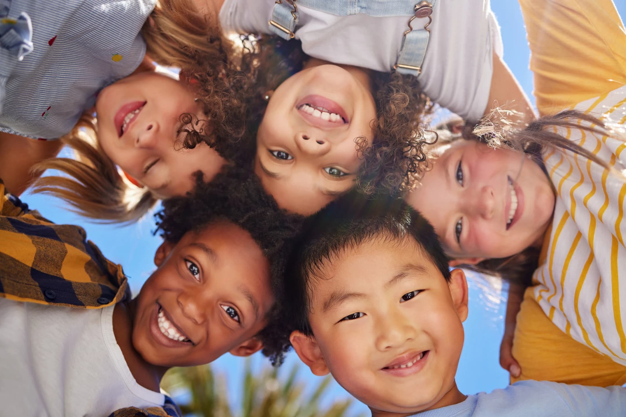 Group of happy children huddling outdoors at an international youth camp