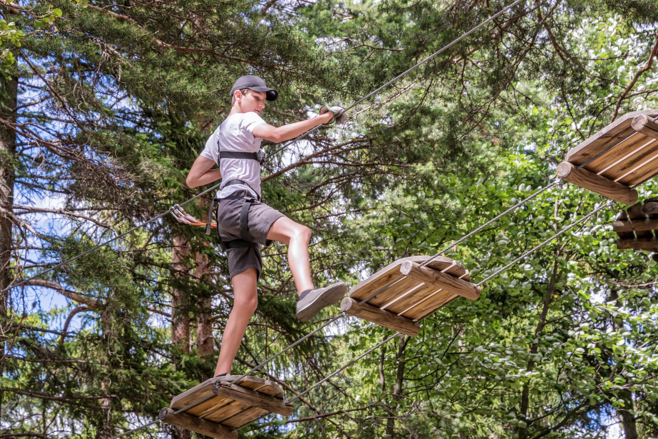 Teen enjoying a high ropes course at an outdoor youth adventure camp