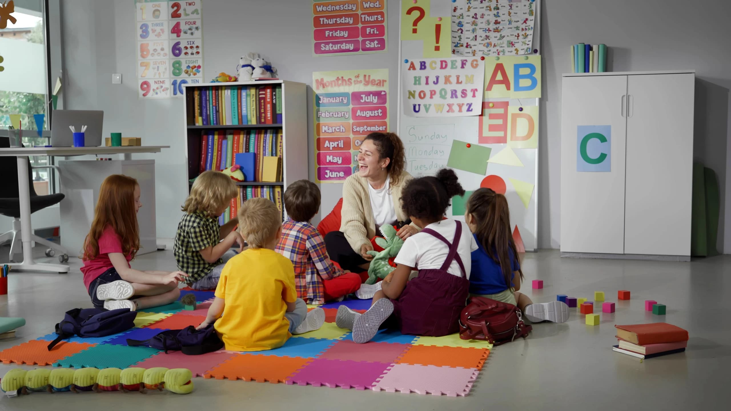 Children sitting with teacher during a creative learning session at summer camp